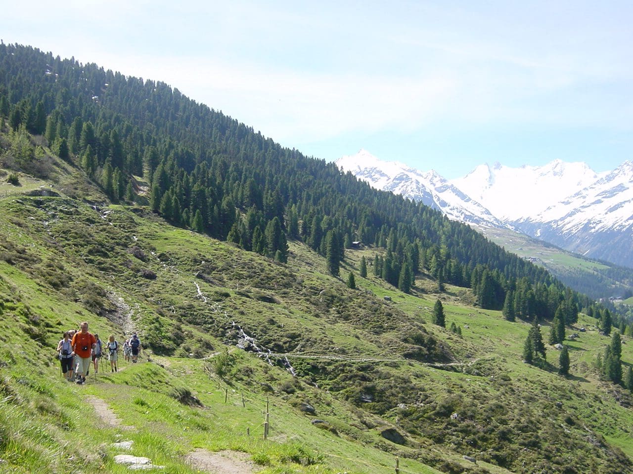 Wanderer auf einem Almweg zum Markkirchl mit bergiger Landschaft im Hintergrund