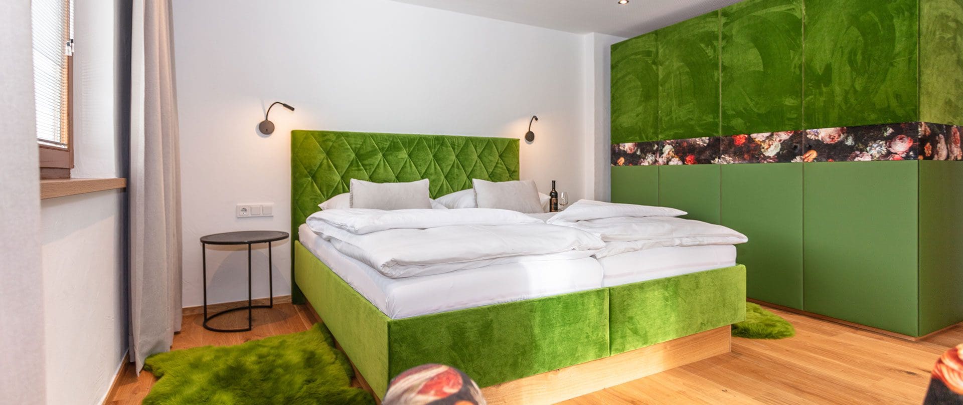 Schlafzimmer mit grünem Bett und grünem Schrank, stilvolle Einrichtung in der Ferienwohnung des Wanderhotels Kirchner