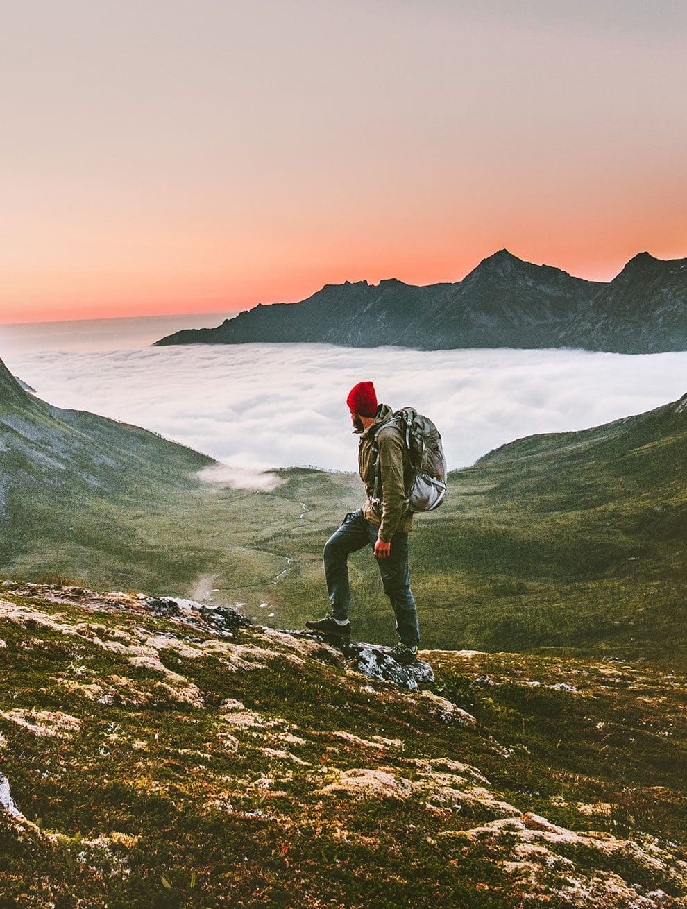 Mann beim Wandern mit Sonnenaufgang über den Wolken in Salzburg